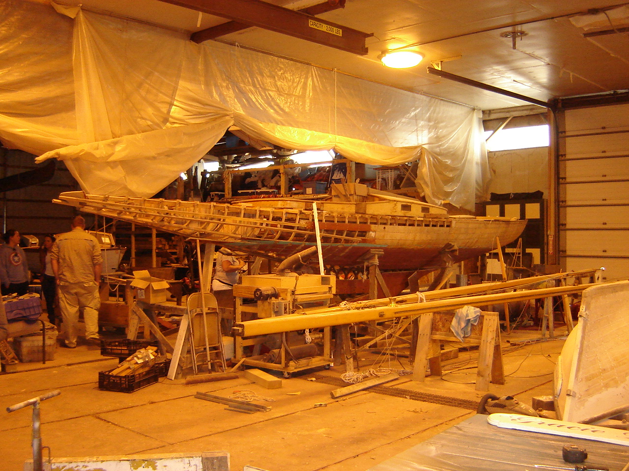 A wooden vessel being inspected at the Maritime Heritage Alliance Boatbuilding Workshops